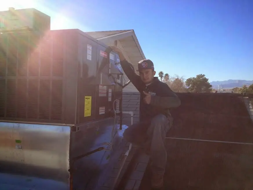 HVAC technician performing AC Tune-Up on a rooftop unit in Cloverdale